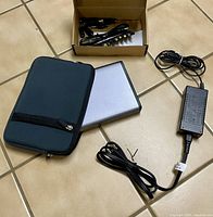 Power bank, legacy adapter box, and Eddie Bauer laptop bag laid on floor.