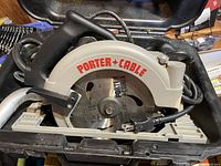Porter & Cable circular saw showing blade and brand name, with attached power cord and black handle.