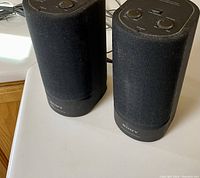 Pair of Sony SRS-X88 active speakers on a white surface showing front and top with control knobs.