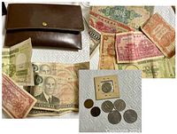 Photo of the vintage brown leather wallet, several coins including a Buffalo nickel, and international paper currencies from China and Costa Rica.