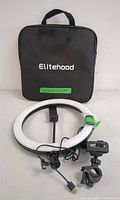 Elitehood branded black zippered carrying case with 12-inch white LED ring light, phone holder, USB power cable, and clamp mounts displayed in front.