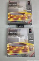 Two boxed 6.5ft Monster IlluminEssence multicolor LED strip lights showing front packaging with LED strip photo and key features.