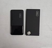 Top view of two black Iniu power banks showing logos and paw print design on one.