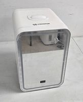 Front angled view of white Cooseon 4L mini fridge with mirror front panel and power button with digital display.