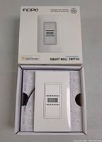 Photo of the Incipio CommandKit smart wall switch out of its box with USB cable visible inside the packaging.