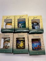 Group photo showing all six boxed Jiangelo Collectible Christmas baubles with different holiday designs.