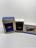 Photo of three boxed Hallmark Christmas ornaments showing the different styles and boxes.