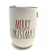 Front of the tumbler showing 'MERRY CHRISTMAS' text in red and green on white ceramic.