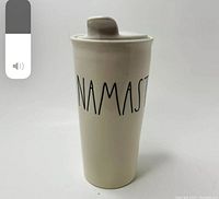 Front view of the tall white ceramic coffee cup with 'NAMASTE' written in black letters.