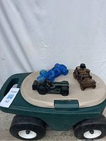 Three vintage Avon glass cars placed on the Step2 rolling garden stool showing their colors and details.