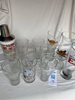 Image showing full set of glasses and cocktail shaker arranged on a white surface.