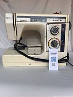 Front full side view of the White Jeans Machine sewing machine with power cord wrapped around base.