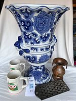 Front view showing all items in the lot: large ceramic planter, two beer Steins (only one for sale), copper container, and grater.