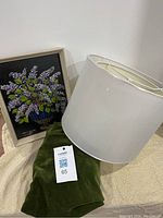 Photo showing original 1987 lilac painting, green velvet card table cover, and white lampshade.