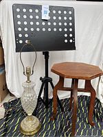 Full view of the three items: music stand, wooden table, and cut glass lamp