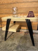 Full view of the vintage table with the bear jar, two egg cups, and lampshade on top.