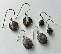 Three pairs of sterling silver earrings displayed on white background, showing front views of all pairs and detail.