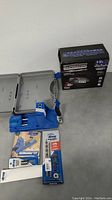 Eliminator battery charger box with charger and Kreg accessories laid out with case open