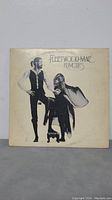 Front cover of Fleetwood Mac Rumours LP album featuring artistic photo of two individuals, light wear visible.