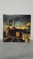 Front cover of Pink Floyd Animals album showing Battersea Power Station with cloudy sky and smoke