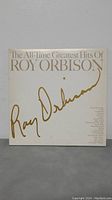 Front cover of the Roy Orbison double LP album titled 'The All-Time Greatest Hits of Roy Orbison', showing white background with gold text and signature.