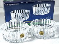Two clear Montparnasse crystal bowls displayed in front of their original blue storage box, showing the brand and model name.