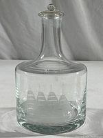 Front view of the glass decanter showing the sailing ship etched design on the main body of the decanter.