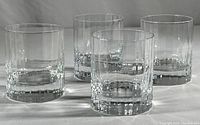 Four clear crystal Luigi Bormioli whisky glasses arranged together showing overall size and design