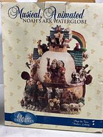 Photo of the original box showing the image of the Noah's Ark musical animated water globe, with branding and tune information.