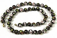 Full view of black cloisonné bead necklace arranged in a loose circle