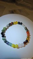 Top view photo of natural mixed gemstone bracelet showing variety of polished round beads of different colors and types.