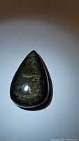 Teardrop shaped, polished natural gold sheen obsidian cabochon with visible golden luster on surface