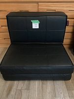 Closed folding chair in black faux leather with square stitch pattern