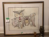 Framed owl print featuring seven stylized owls with multiple colors and patterns, signed and numbered.