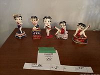 All five figurines in a row on table