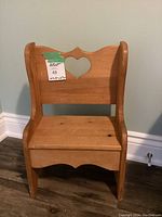 Front view of solid wood child's chair with heart cutout, shows size label and scratches.