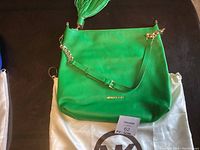 Front of vintage green Michael Kors bag showing gold hardware and tassel