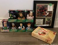 Overall image showing all boxed CelebriDucks rubber ducks, framed Wizard of Oz picture collage, and hardcover books arranged on floor.