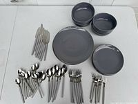 Overview of the dishes and cutlery set including bowls, plates, knives, forks, and spoons.