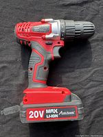 Side view of red and black cordless drill with 20V Max Li-Ion battery attached, showing label and handle grip.
