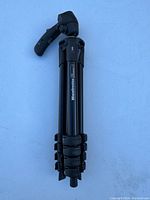Folded Manfrotto tripod showing branding, leg sections, and locking levers.