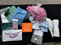 Full lot of assorted sewing items including fabric pieces, sewing roller kit, needles, and rolls of interfacing material.