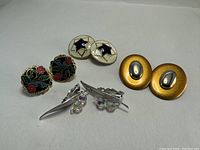 Photo showing four pairs of vintage clip on earrings on a white background.