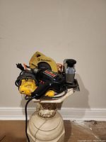 Image showing a Black & Decker 7 1/4" circular saw, Dewalt and Craftsman drills on a pedestal.