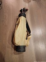 Photo of the yellow golf bag containing the vintage wooden golf clubs showing the bag's overall condition.