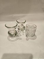 Three small glasses displayed - two matching clear glass espresso/shot glasses with handles and one vintage-style cut glass shot glass, all approximately 3 inches tall.