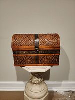 Front view of closed bamboo wicker treasure chest showing curved lid and metal latch