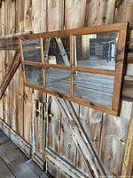 Photo showing the rectangular wood framed mirror mounted on a rustic wooden barn wall, highlighting the six mirror sections and natural wood finish.