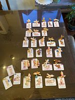 All 28 Oodles Babies figures displayed with their matching collectible cards arranged on a glass surface.