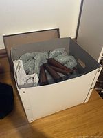 Box containing four wooden tapered legs along with some packaging material